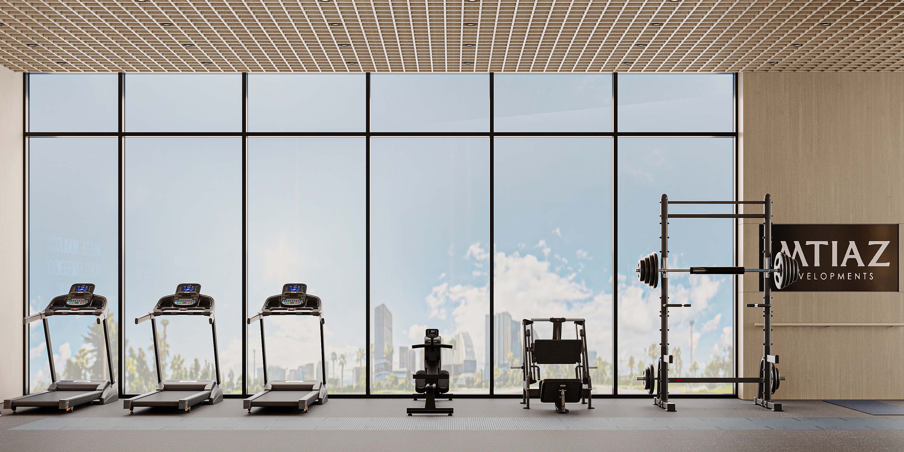 Cove Grand By Imtiaz A modern gym with treadmills, a weight bench, and a squat rack, featuring large windows overlooking a cityscape.